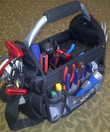 A tool bag with assorted tools resting on the floor of a home in Charleston, serving as a reminder for appliance inspection steps.