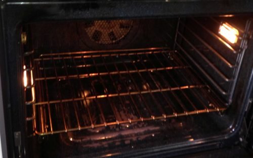 A black oven with a rack in a kitchen of Charleston, illustrating essential tips for keeping your oven clean and well maintained.