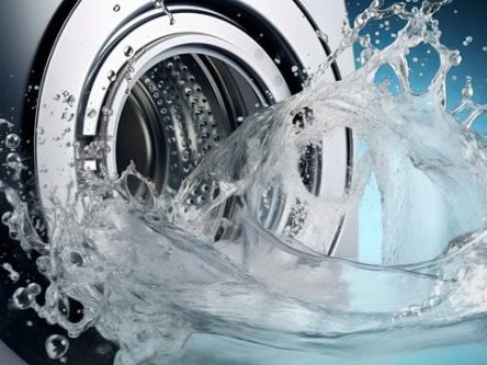 Water splashes from a washing machine in a Charleston home, highlighting a problem with drainage that requires fixing.