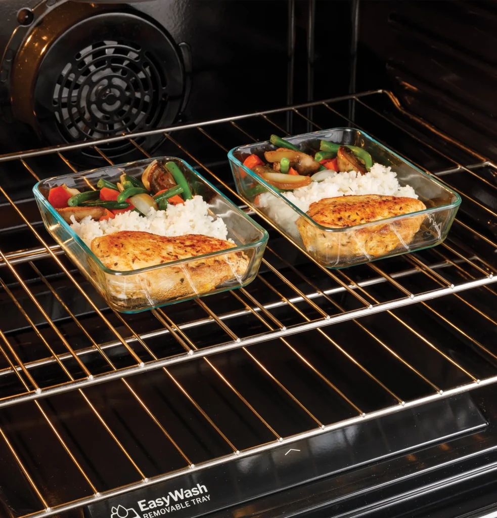 Two glass containers filled with food placed on an oven rack in a Charleston kitchen, highlighting the issue of the GE oven not heating properly.