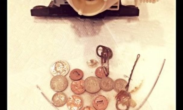 An image of a water pump and coins on a table in a Charleston home, representing issues with washer drainage.