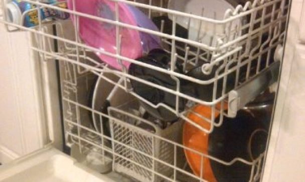 A fully loaded dishwasher filled with various dishes, pots, and pans in a Charleston kitchen, demonstrating proper loading techniques.