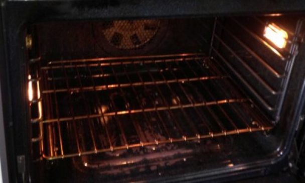 A black oven with a rack in a kitchen of Charleston, illustrating essential tips for keeping your oven clean and well maintained.